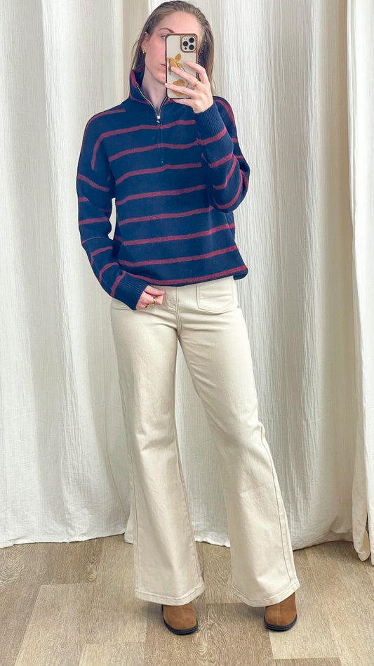 Pull col zippé bleu marine à rayures bordeaux coupe oversize femme, porté avec jean flare écru et bottines camel