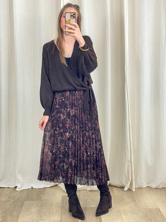 Jupe midi plissée imprimé floral bordeaux et noir femme portée avec pull cache-cœur et bottes noires