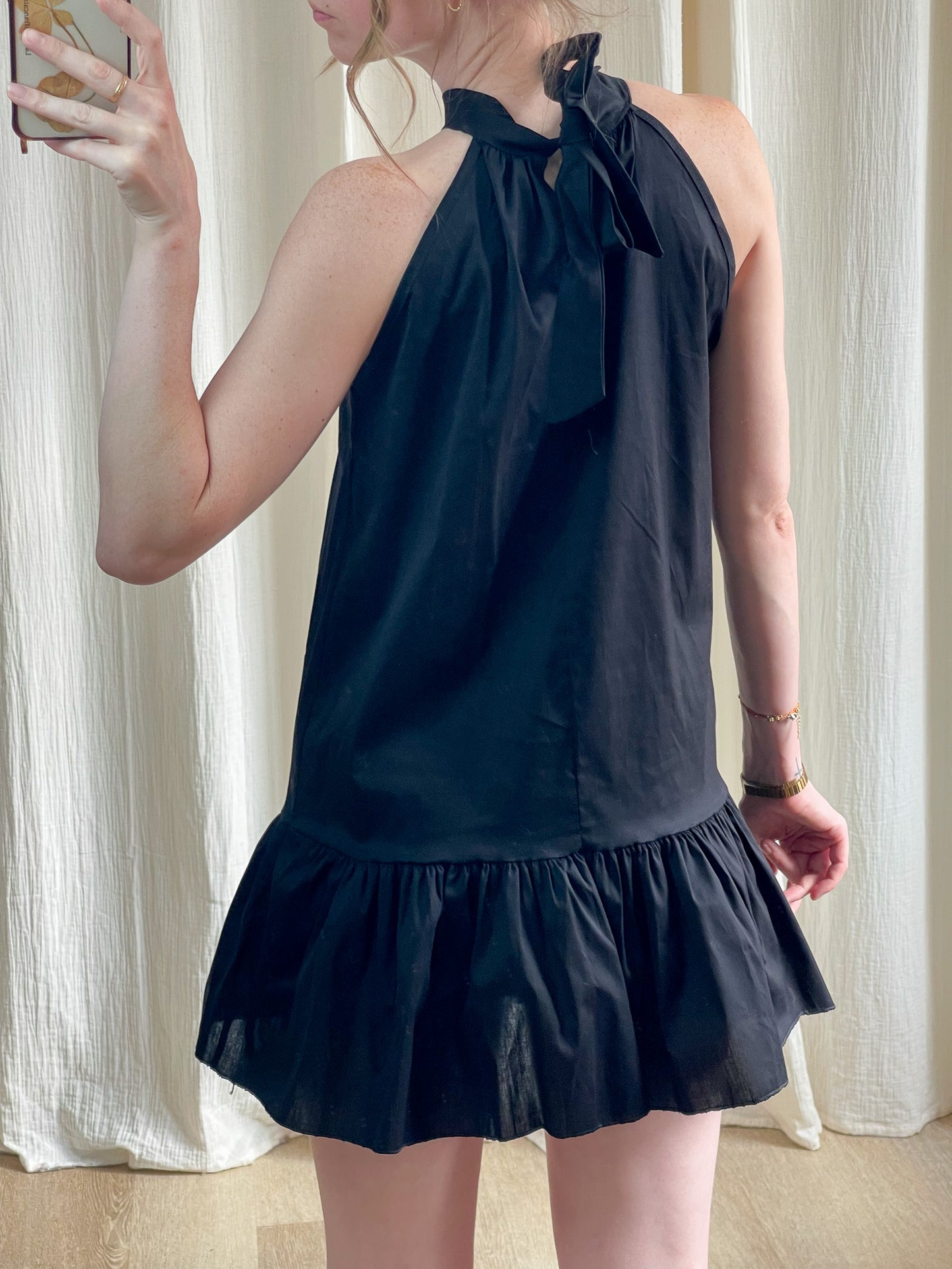 Robe noire courte col montant avec nœud et volant bas femme style chic minimaliste