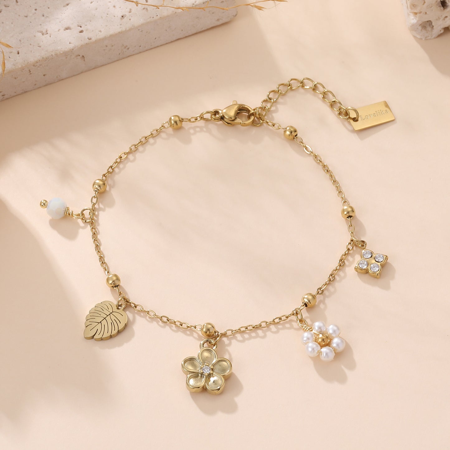 Bracelet chaîne doré femme avec breloques fleur, feuille monstera et perles blanches style bohème chic Lovelika