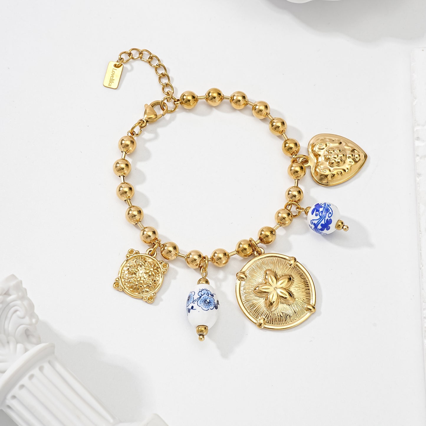 Bracelet à breloques doré avec perles rondes, médaillons fleuris et perles céramique bleu blanc style bohème chic femme