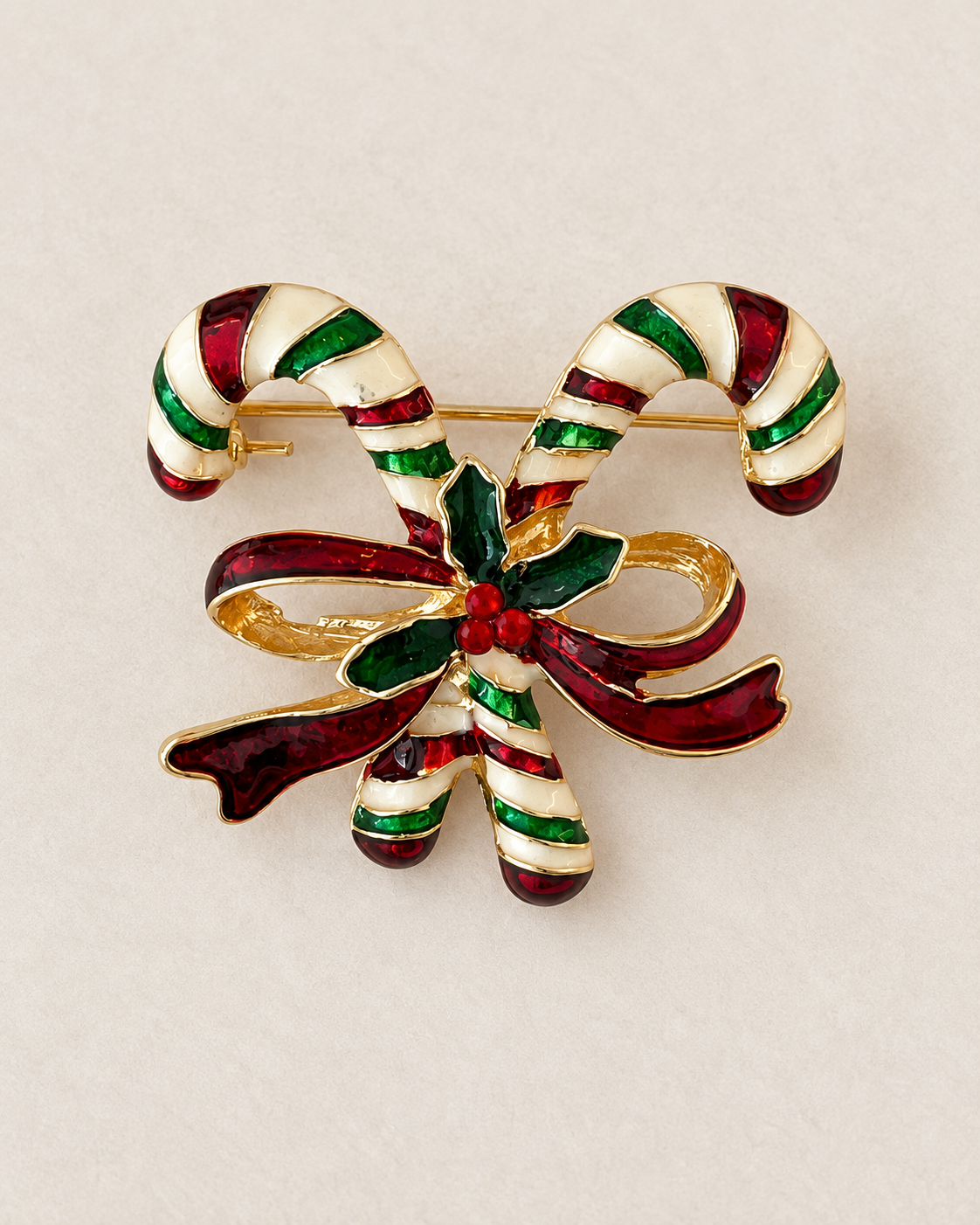 Broche sucre d'orge de Noël dorée émaillée rouge vert et blanc motif cannes à sucre et nœud holly accessoire festif femme