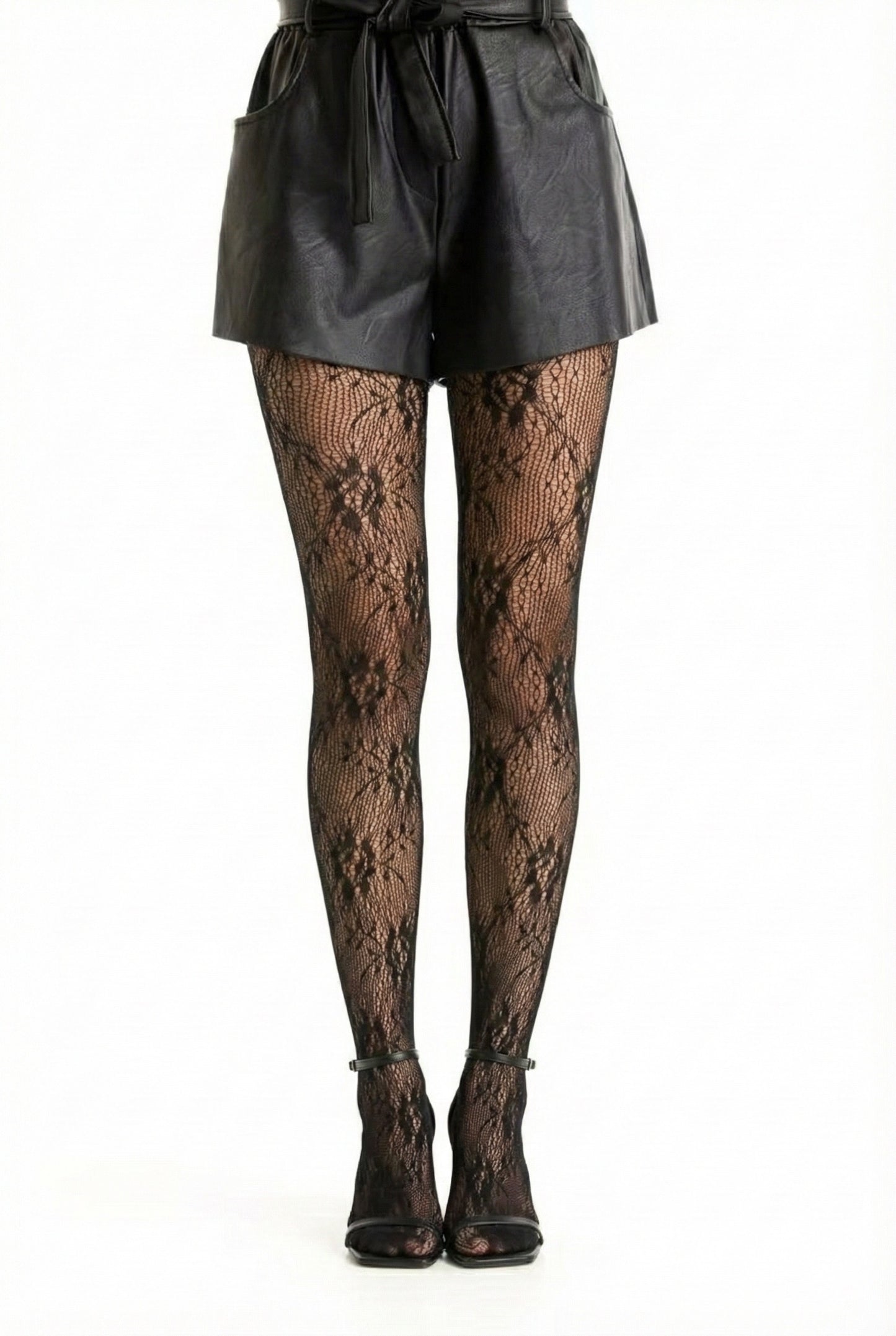 Collant noir en résille et dentelle florale porté avec un short noir