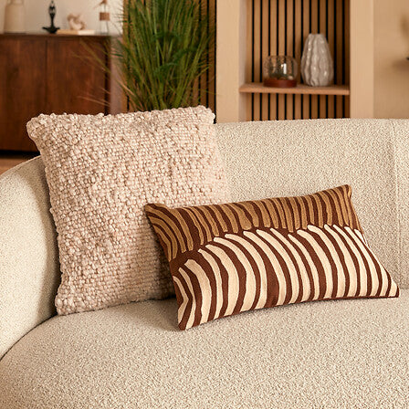 Coussin Volna rectangulaire motif rayures marron et beige sur canapé bouclette écru déco bohème chic salon