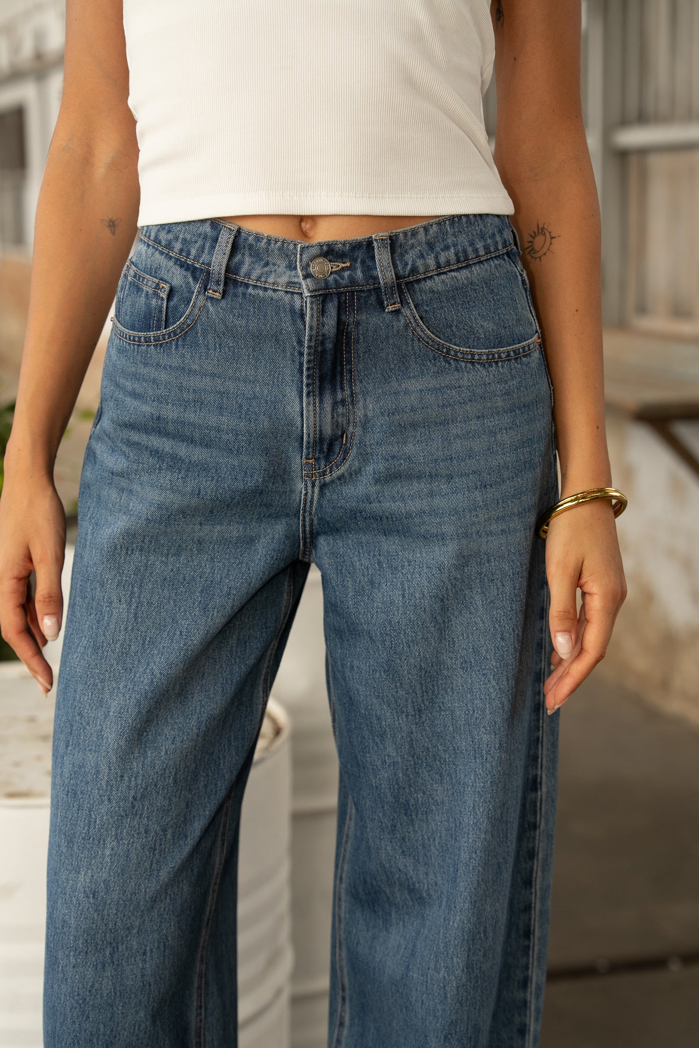 Jean Oraije Brune coupe barrel en denim bleu porté de face en extérieur