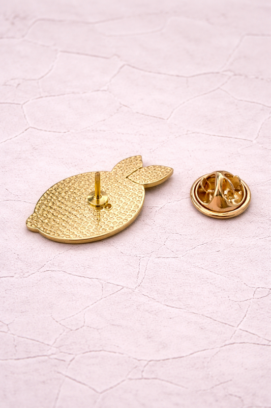 Dos du pin's citron avec attache papillon dorée