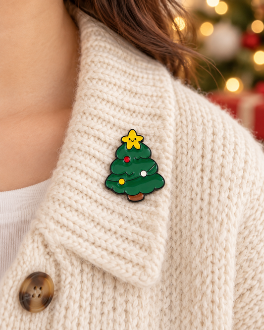 Pin's sapin de Noël vert émaillé avec étoile kawaii jaune porté sur gilet tricot écru accessoire fantaisie fêtes femme