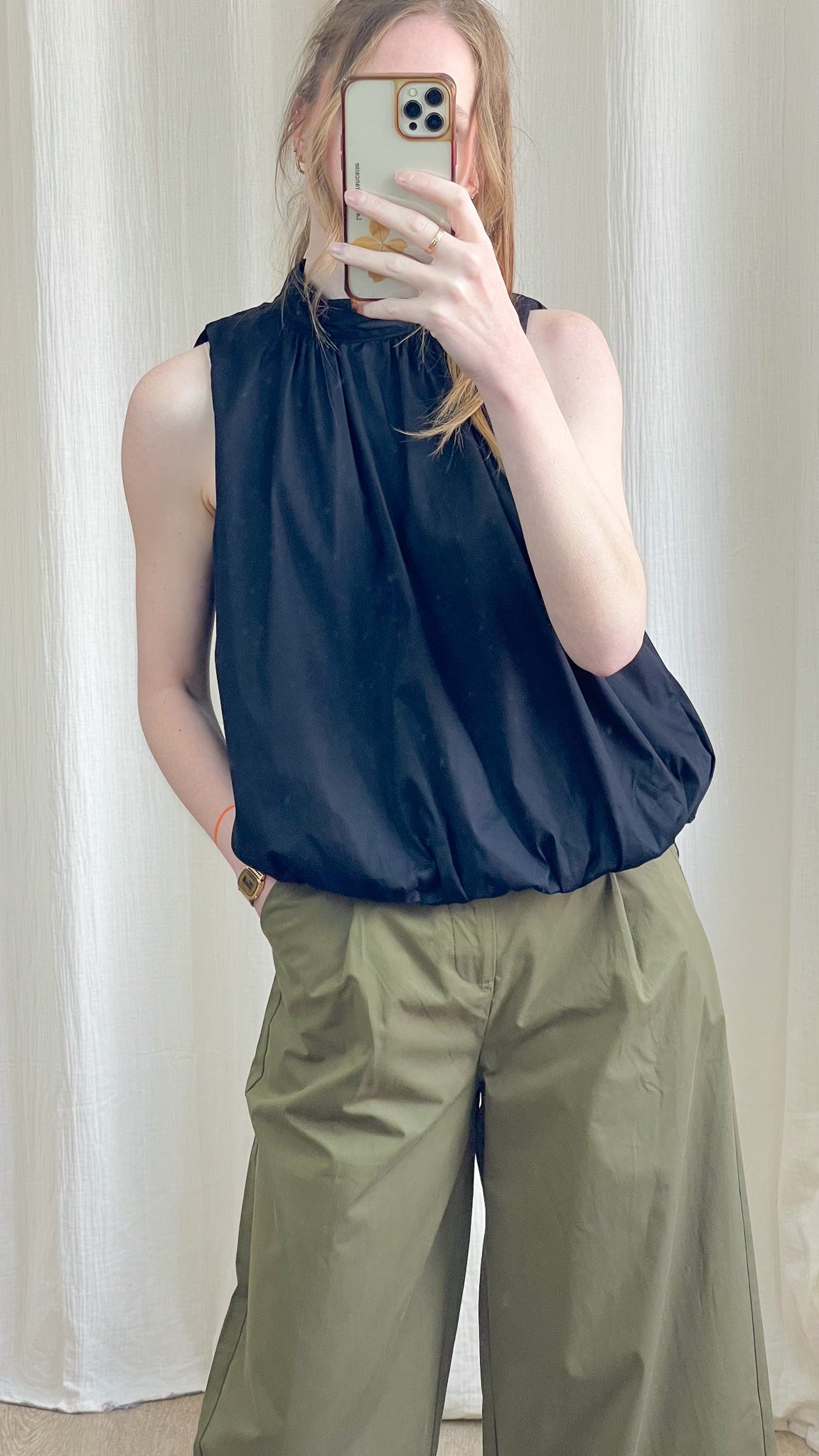 Blouse dos nu noire col montant à nouer, coupe fluide et ample, portée avec pantalon cargo kaki femme