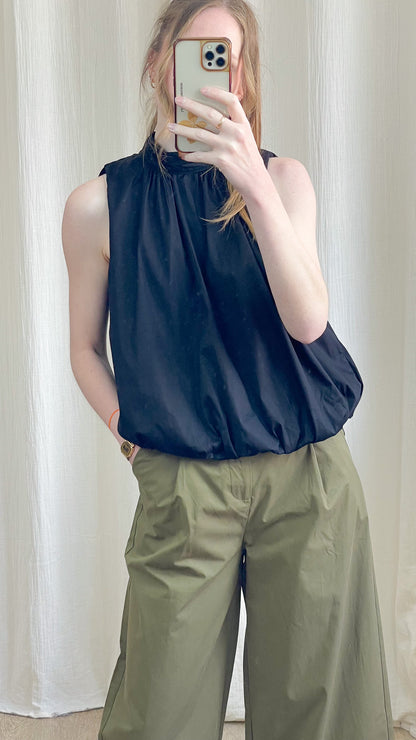 Blouse dos nu noire col montant à nouer, coupe fluide et ample, portée avec pantalon cargo kaki femme