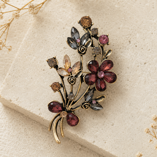 Broche bouquet floral vintage en métal doré avec cristaux bordeaux, gris et champagne, épinglette fleur femme élégante