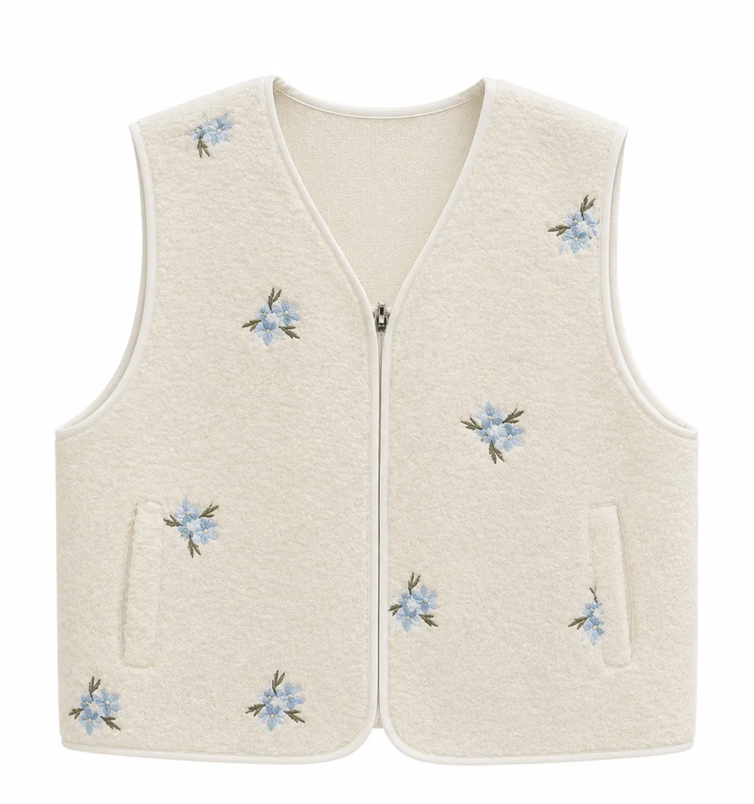Gilet sans manches beige en laine bouclée avec broderies fleurs bleues et fermeture zippée femme style champêtre