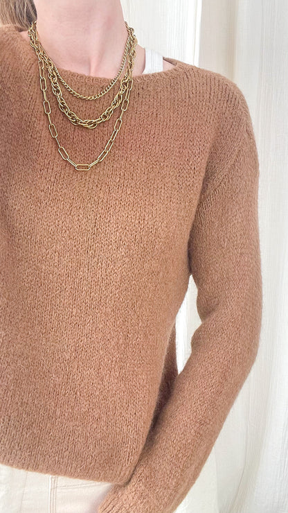 Pull femme marron camel en maille douce col rond, style minimaliste chic porté avec colliers dorés superposés