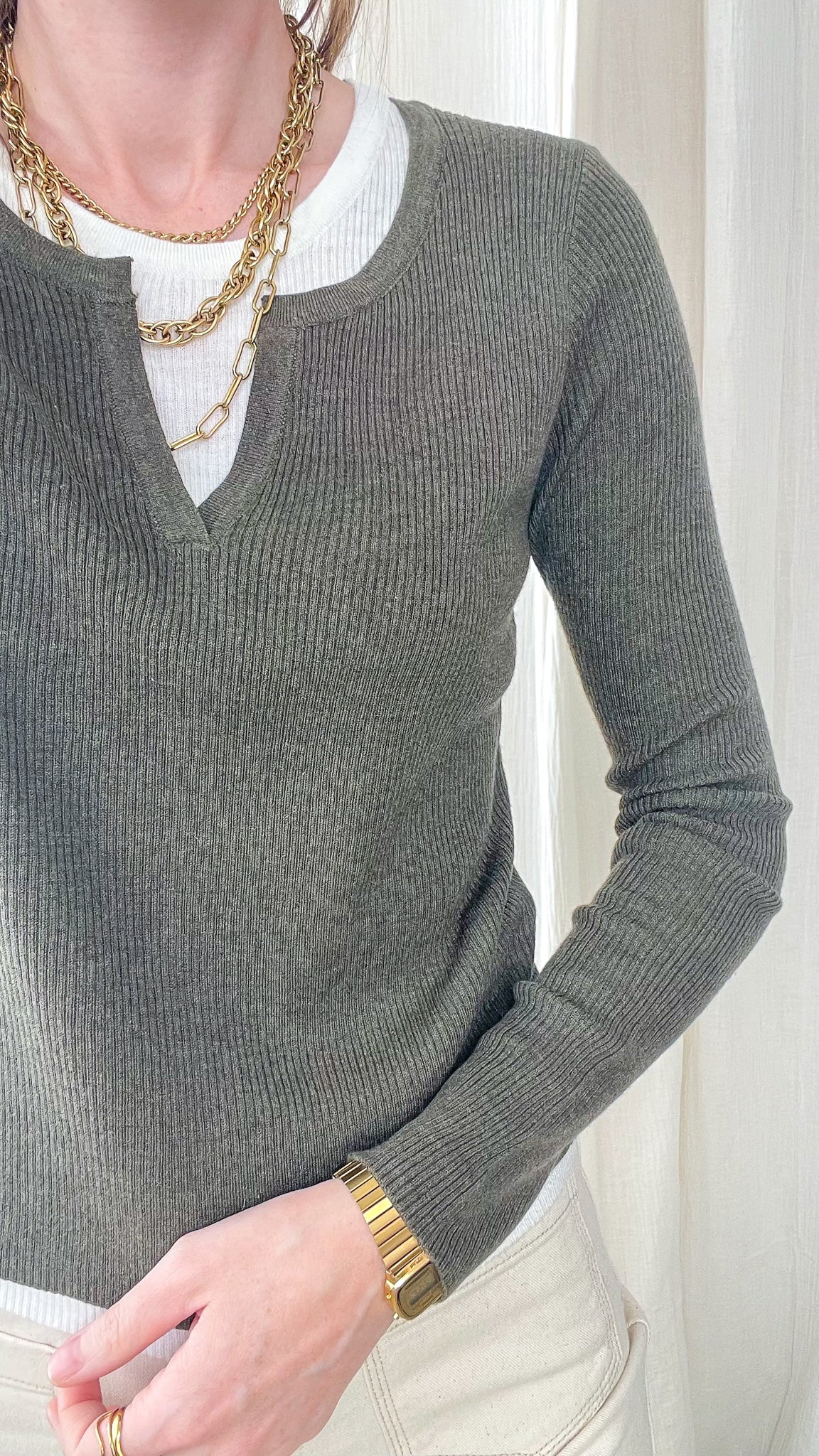 Pull maille côtelée kaki effet 2-en-1 col échancré femme porté avec t-shirt blanc et accessoires dorés