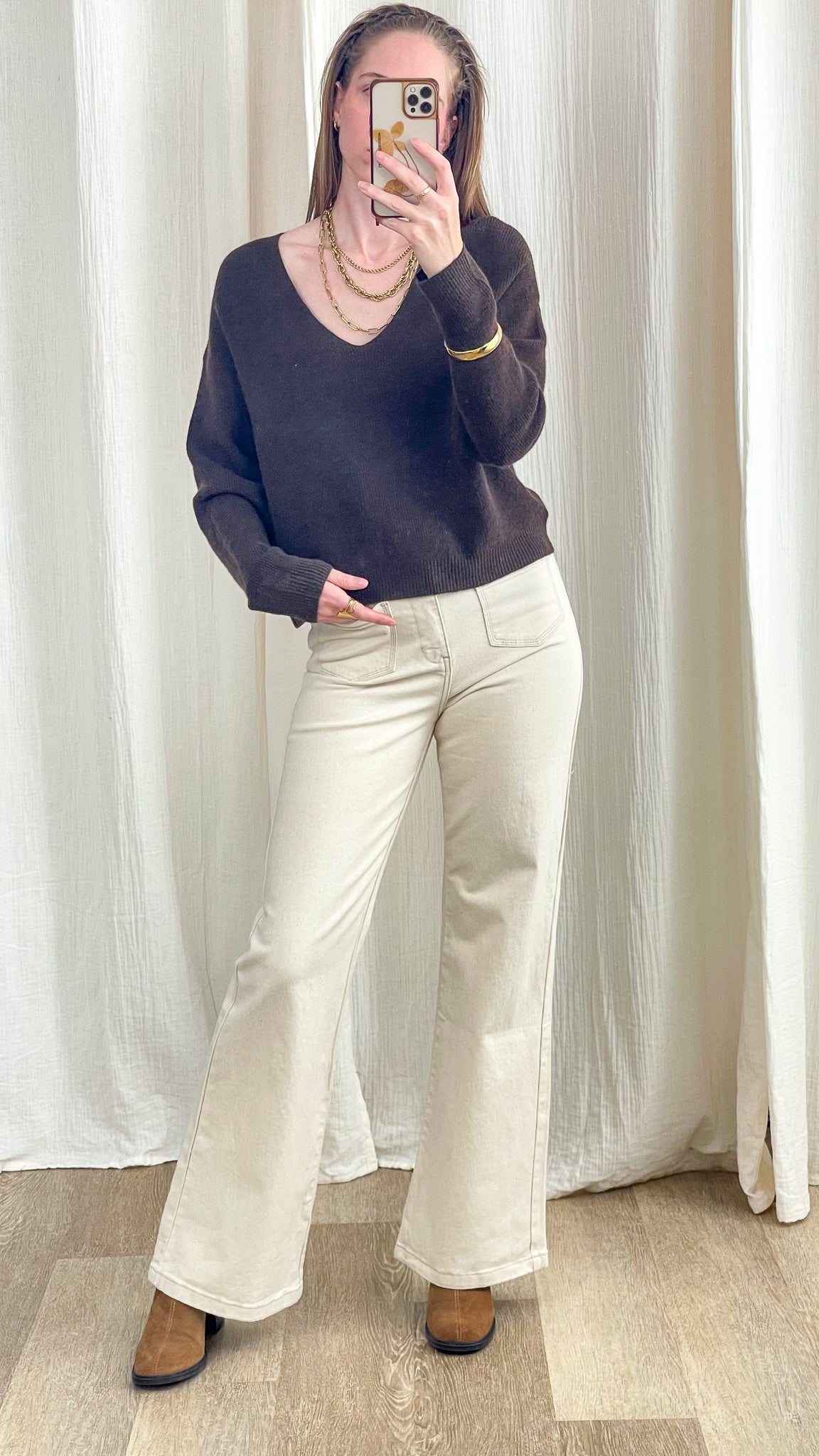 Pull court col V marron chocolat coupe oversize femme associé à un pantalon flare beige et bottines camel style casual chic