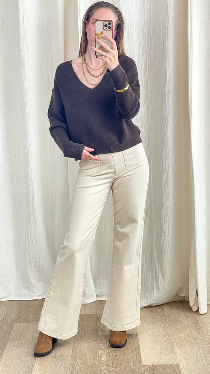 Pull court col V marron chocolat coupe oversize femme associé à un pantalon flare beige et bottines camel style casual chic