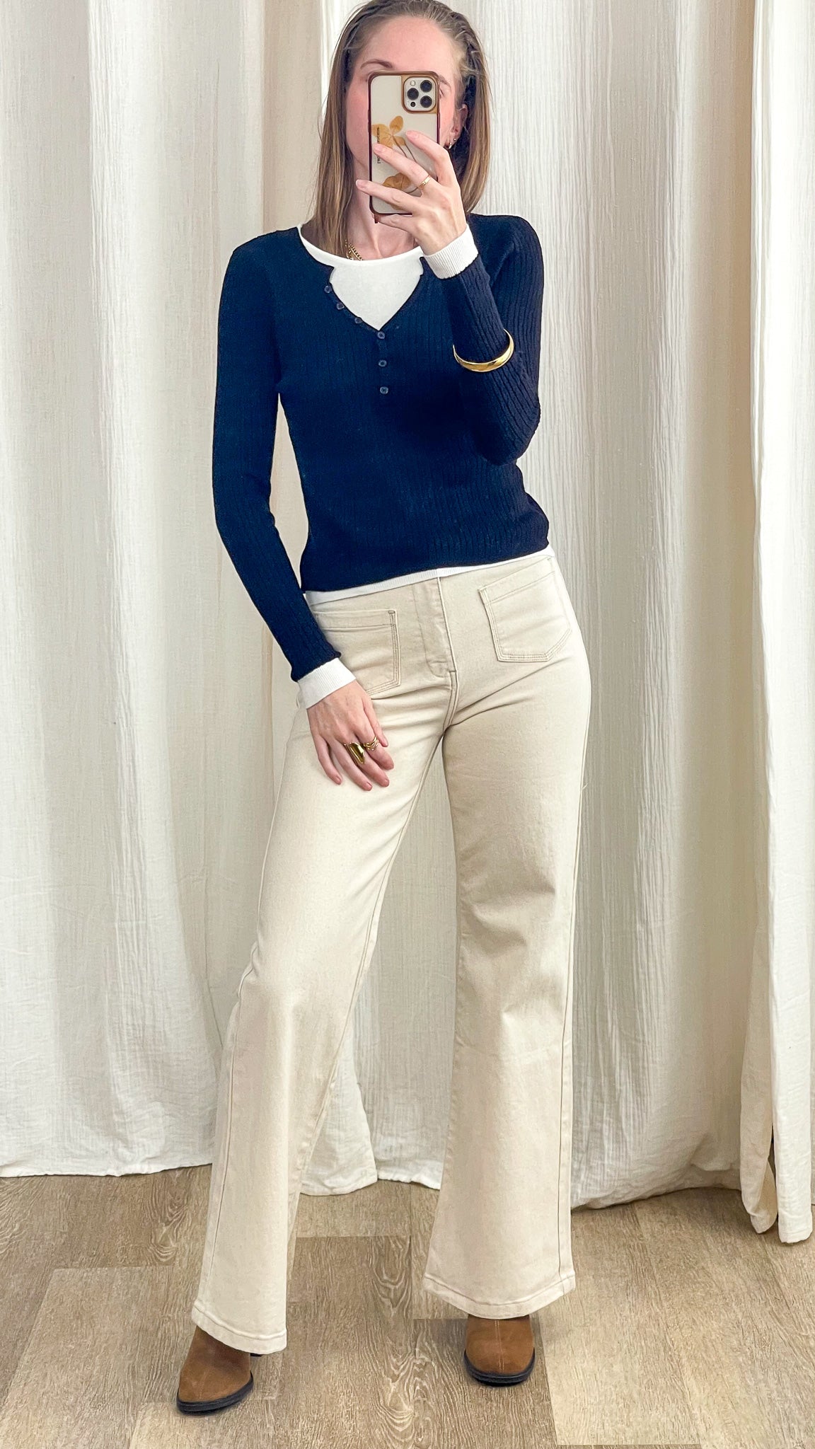 Pull col V bleu marine côtelé boutonné porté sur t-shirt blanc avec pantalon écru flare femme style casual chic