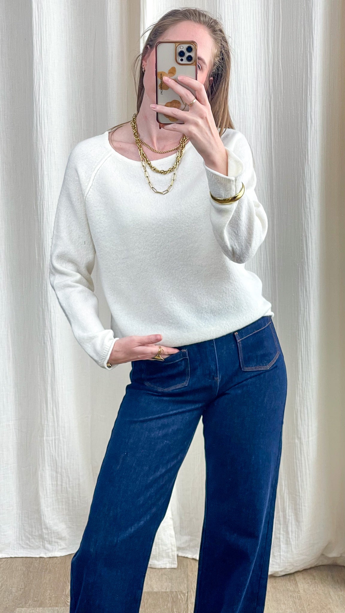Pull femme blanc cassé col rond manches raglan en maille douce porté avec jean large bleu brut et colliers dorés