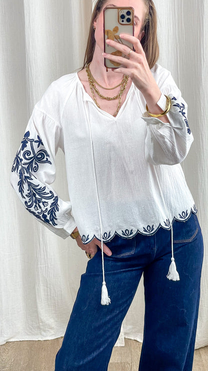 Blouse Alice blanche broderies bleues manches bouffantes style bohème femme avec détails tassels et ourlet festonné