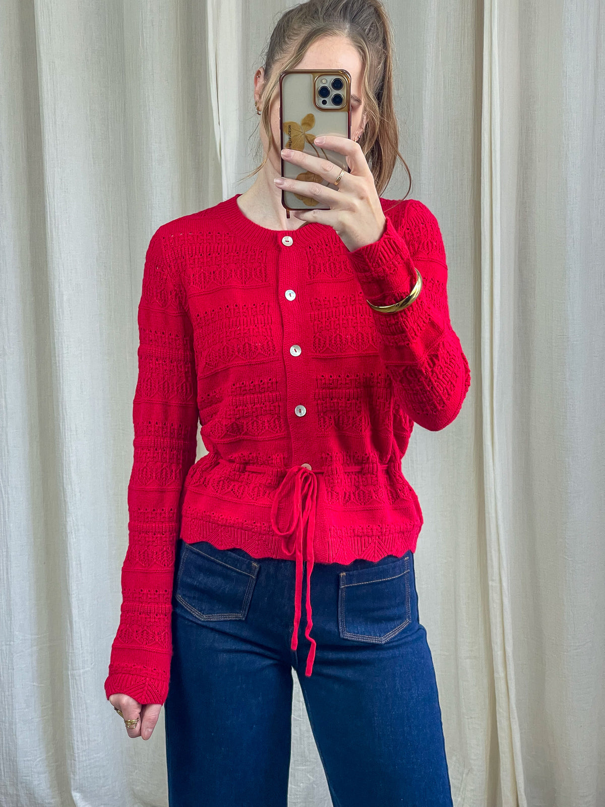 Gilet rouge maille ajourée femme avec boutons nacrés et lien de serrage taille coupe cintrée style vintage
