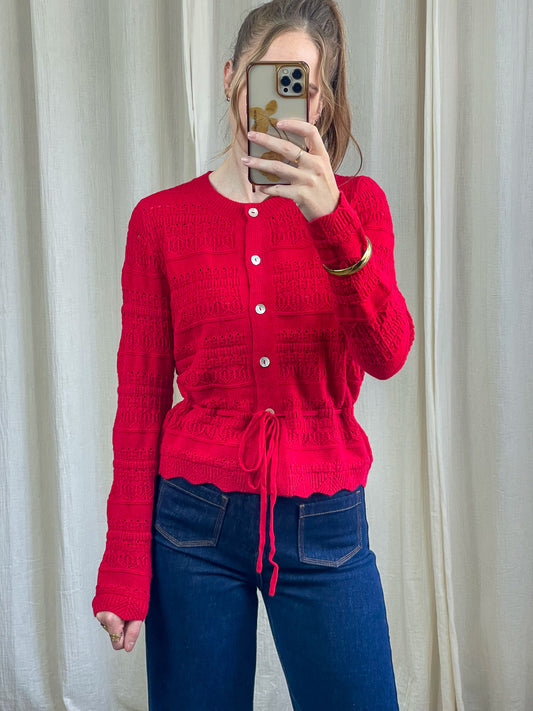 Gilet rouge maille ajourée femme avec boutons nacrés et lien de serrage taille coupe cintrée style vintage