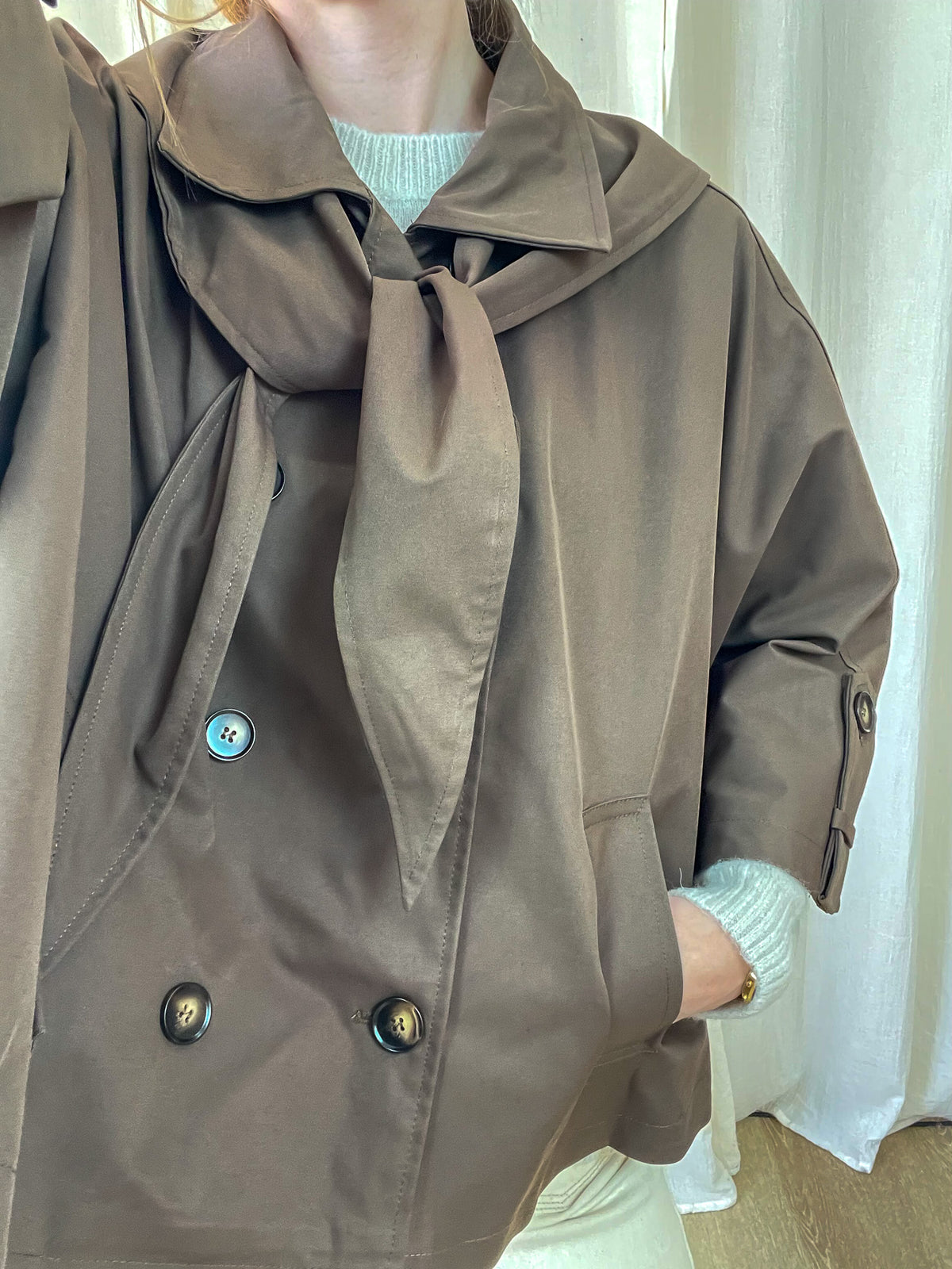 Trench court marron col foulard noué double boutonnage femme porté sur pull vert menthe style chic automne