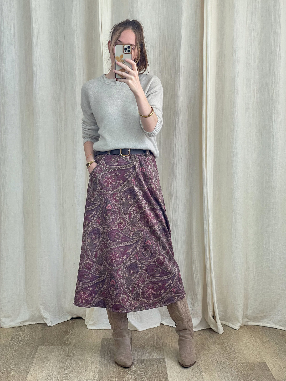 Jupe midi motif cachemire violet rose taille haute avec ceinture portée avec pull gris et bottes femme