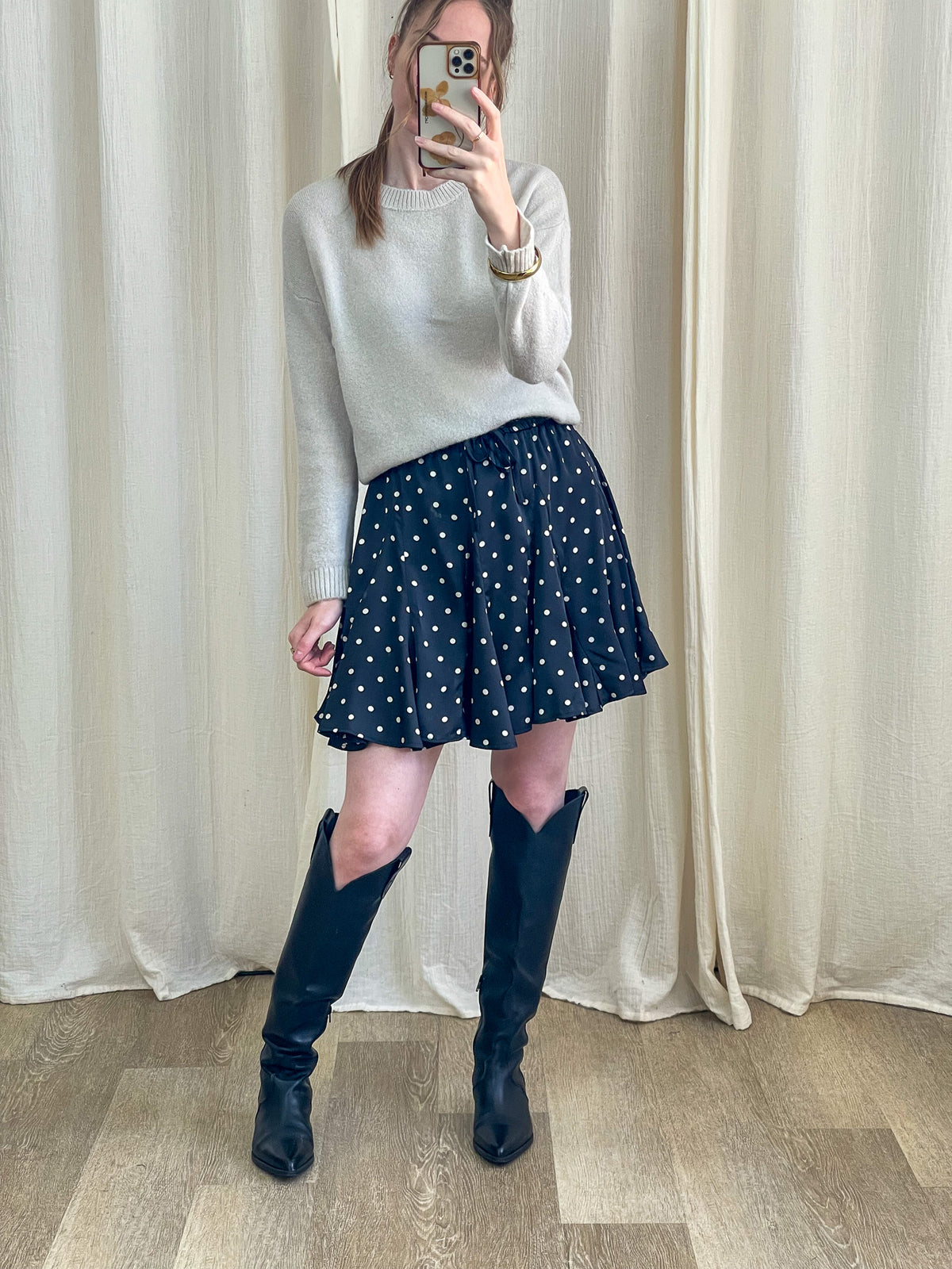 Jupe patineuse à pois noir et blanc fluide taille élastique portée avec pull gris et bottes western femme