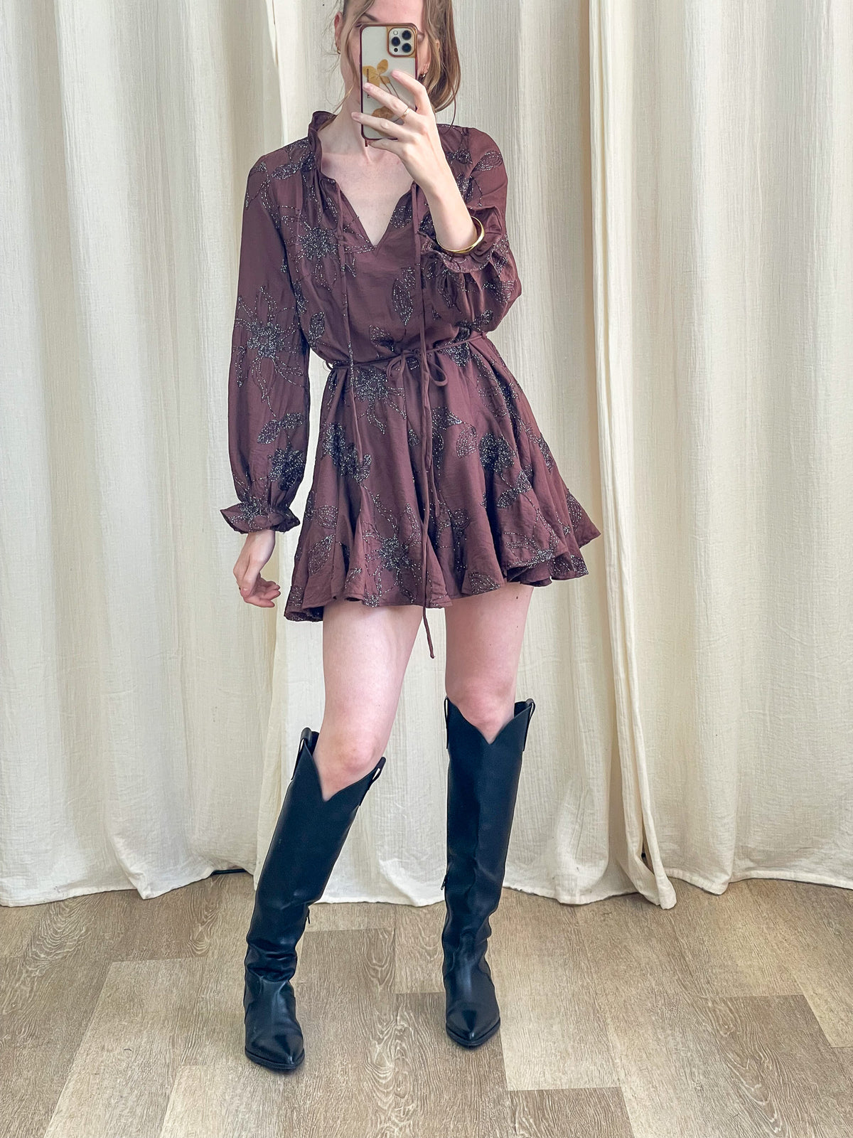 Robe patineuse marron à imprimé floral brillant avec manches bouffantes et décolleté V portée avec bottes western noires