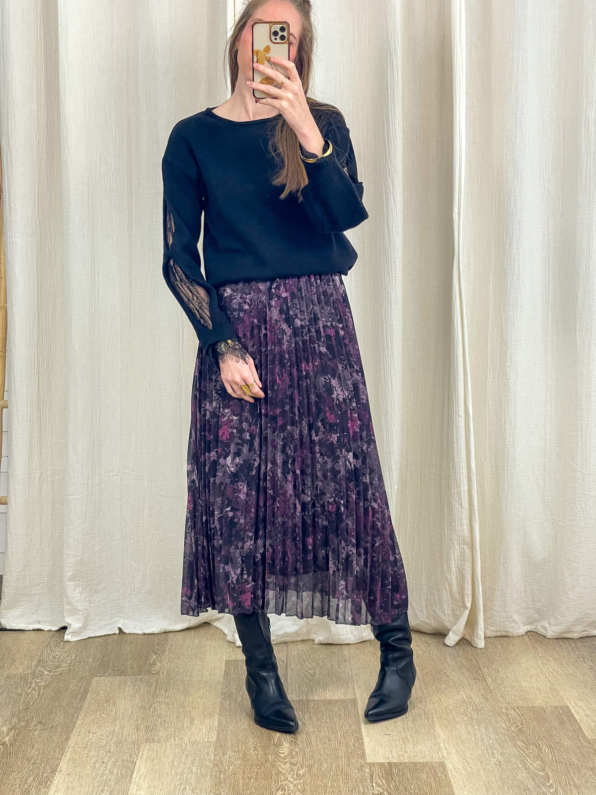 Jupe midi plissée imprimé floral violet foncé femme portée avec pull noir et bottes cuir noir
