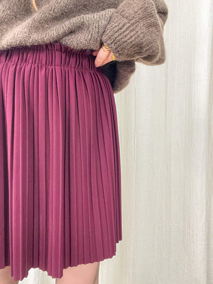Jupe courte plissée bordeaux taille haute élastique portée avec pull en maille taupe femme