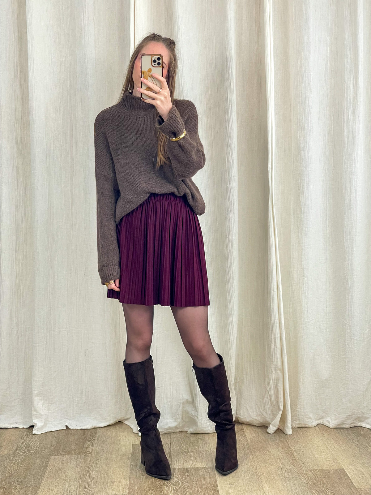 Pull col montant marron en baby alpaga porté avec jupe plissée bordeaux et bottes hautes look automne femme