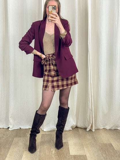 Blazer oversize bordeaux col châle femme porté avec jupe écossaise et bottes hautes noires, style casual chic automne