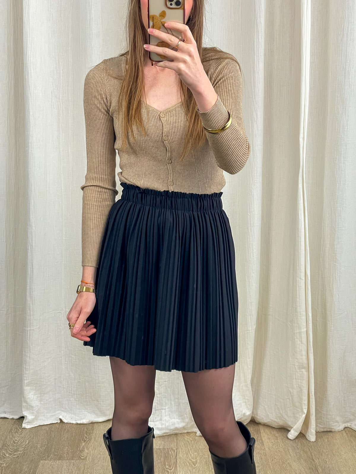 Jupe courte plissée noire taille haute élastique portée avec cardigan beige, jupe plissée femme tendance