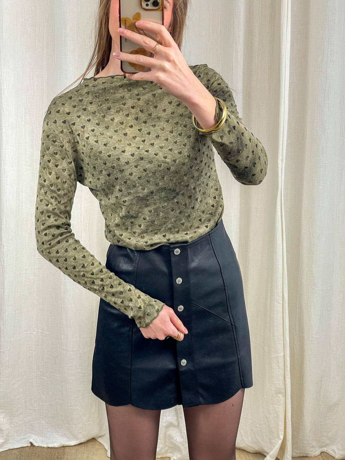 Top mesh kaki imprimé cœurs manches longues femme, porté avec mini-jupe cuir noire boutonnée