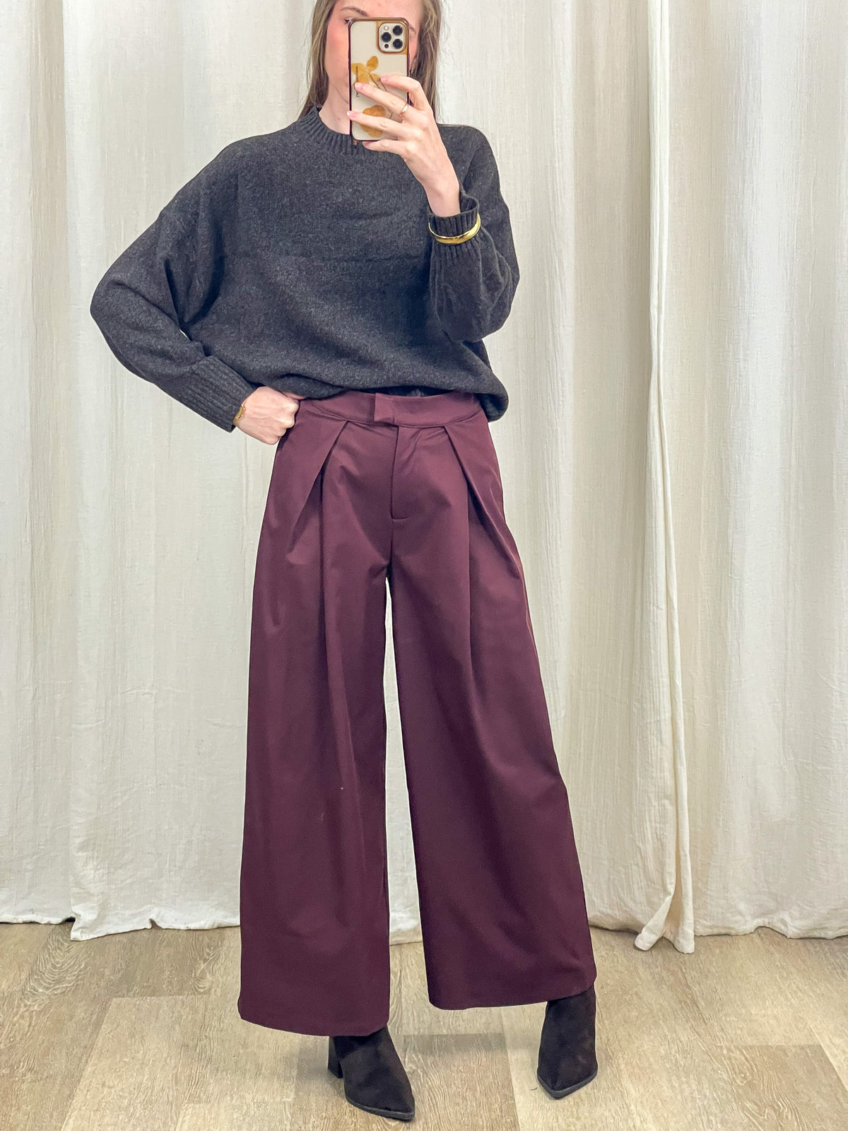Pantalon large bordeaux à pinces taille haute femme porté avec pull gris et bottines noires style habillé chic