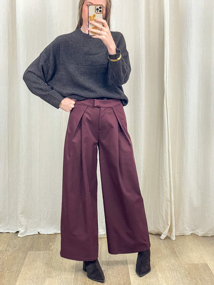 Pantalon large bordeaux à pinces taille haute femme porté avec pull gris et bottines noires style habillé chic