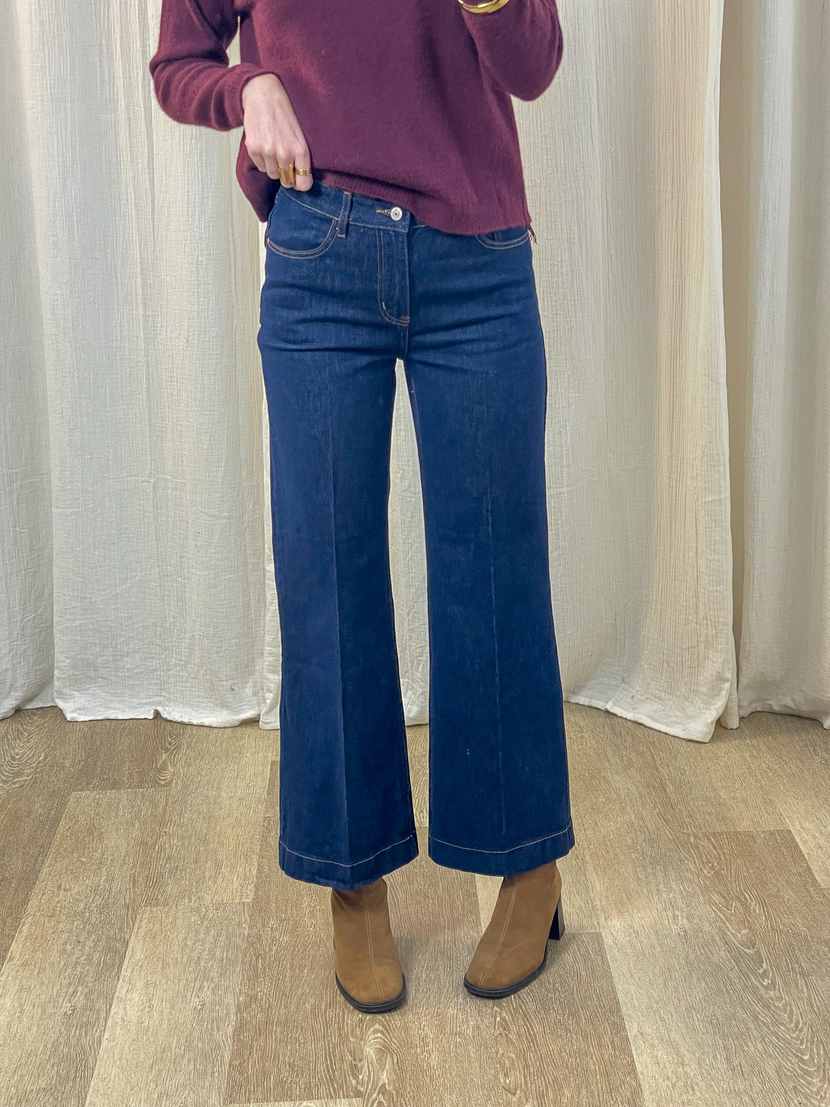Jean wide leg taille haute bleu brut femme coupe évasée style années 70 porté avec pull bordeaux et bottines camel
