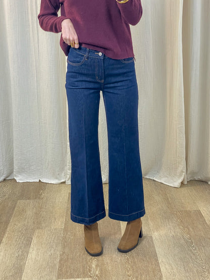 Jean wide leg taille haute bleu brut femme coupe évasée style années 70 porté avec pull bordeaux et bottines camel