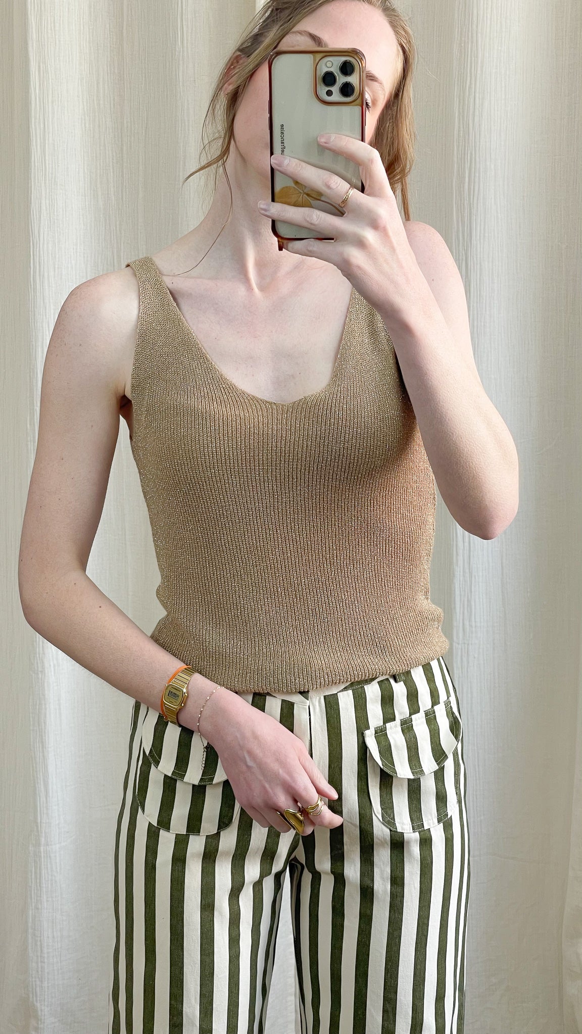Top débardeur doré pailleté en maille lurex fine à encolure arrondie porté avec pantalon rayé vert et blanc femme