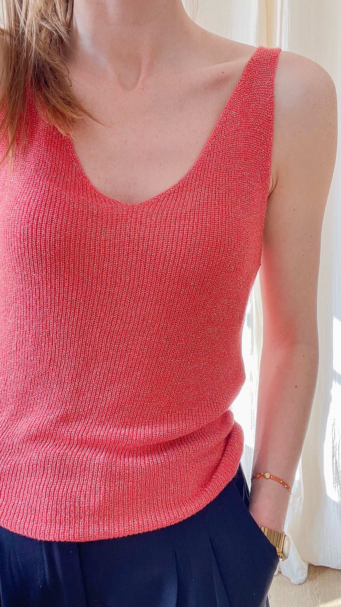 Top débardeur femme corail à paillettes en maille fine lurex avec décolleté en V et bretelles larges porté avec pantalon bleu