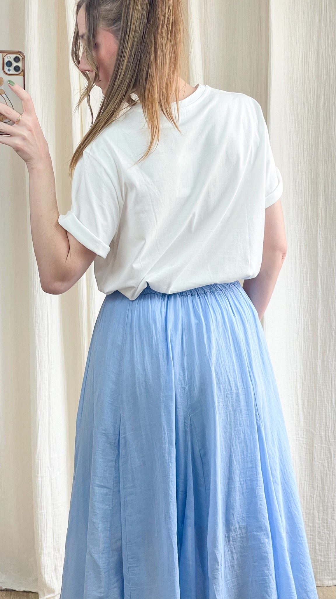 T-shirt blanc oversize manches retroussées femme porté avec jupe longue bleue style décontracté