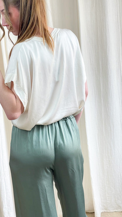 Blouse Samantha blanche oversize manches courtes femme associée à un pantalon satiné vert sauge taille élastique