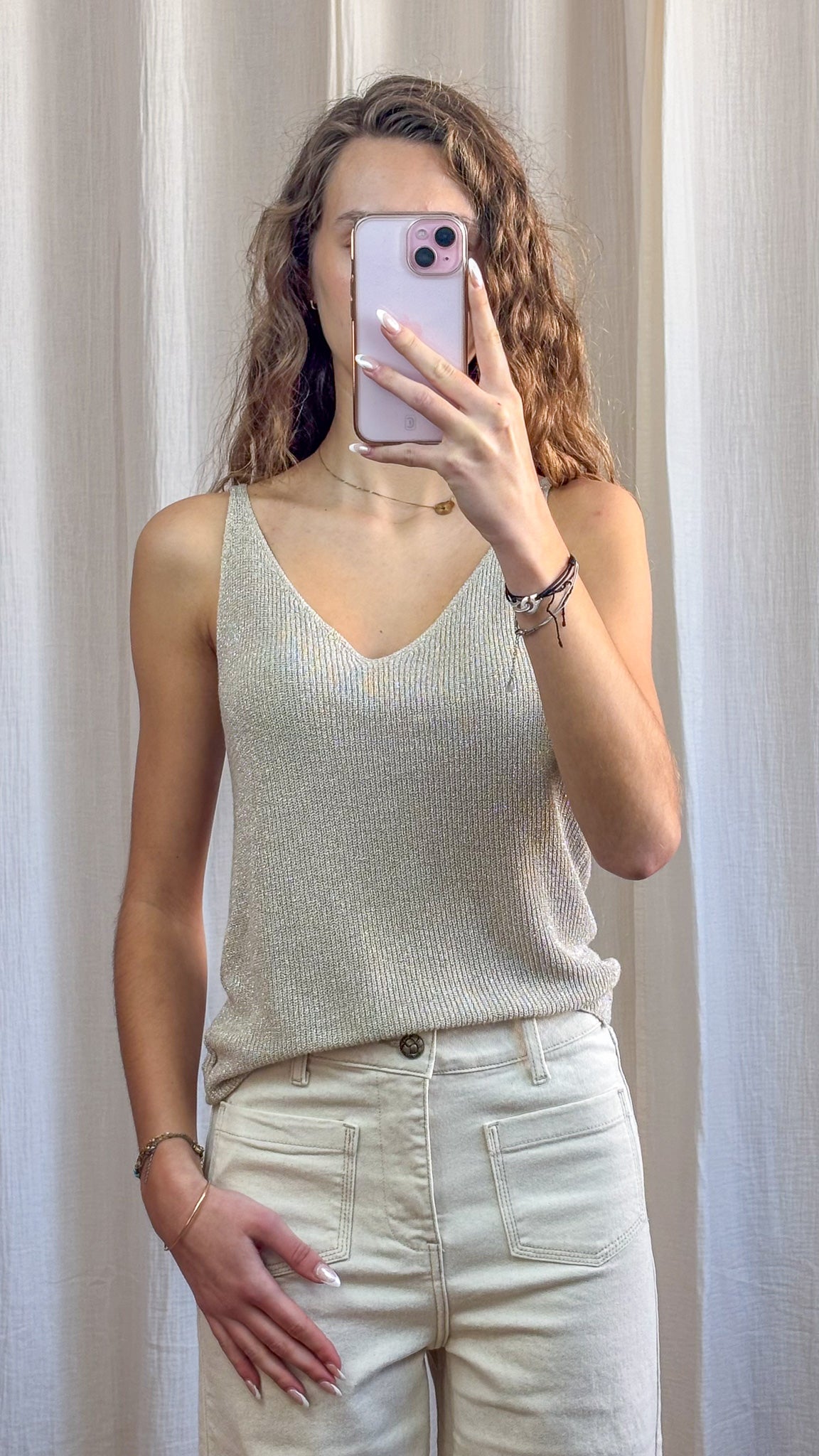 Top débardeur paillettes lurex doré femme à fines bretelles et décolleté V porté avec jean blanc taille haute