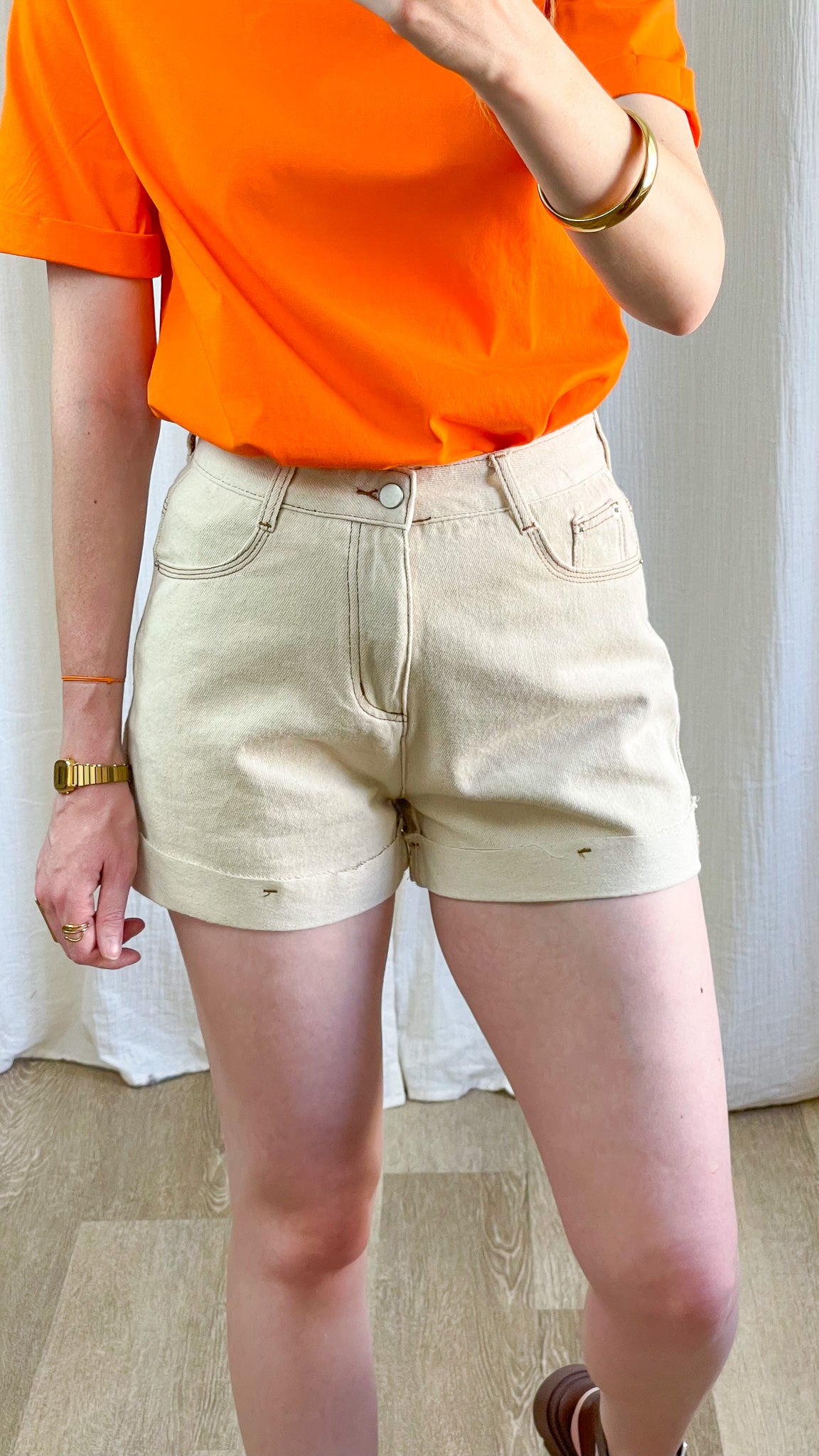 Short beige taille haute en jean avec revers, coupe mom vintage femme, porté avec t-shirt orange vif