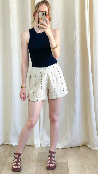 Short Josette beige à rayures verticales noires en lin, coupe ample taille haute, porté avec débardeur noir femme été