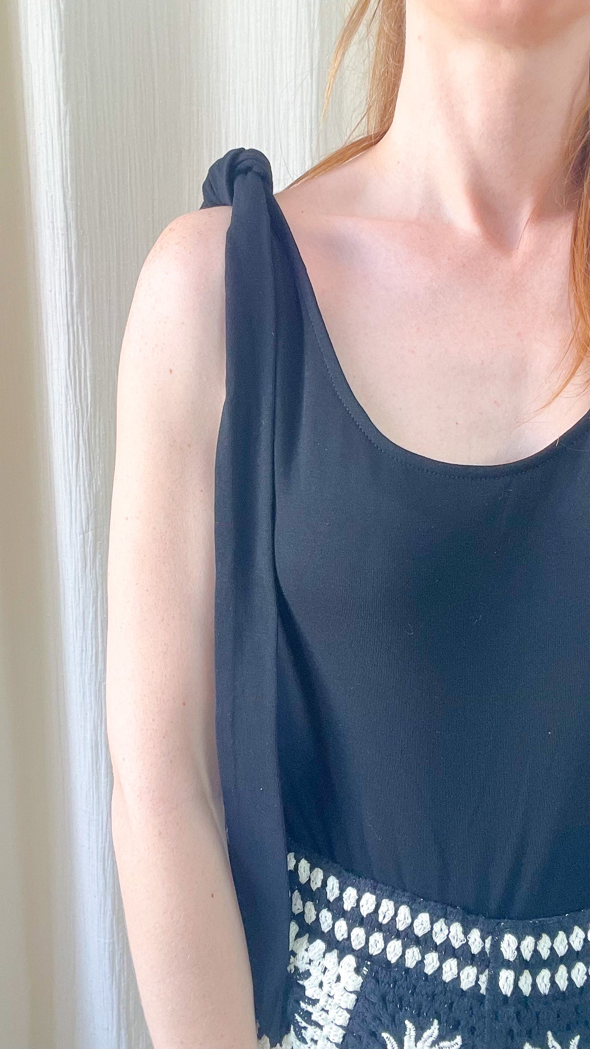 Top noir femme à bretelles nouées sur l'épaule avec détail broderie ethnique blanche, style bohème chic