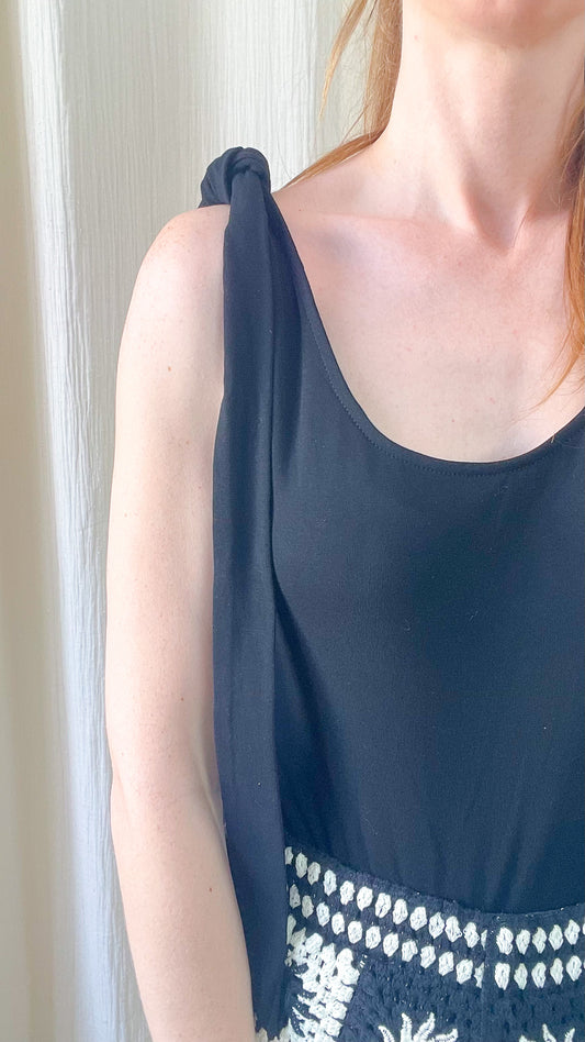 Top noir femme à bretelles nouées sur l'épaule avec détail broderie ethnique blanche, style bohème chic