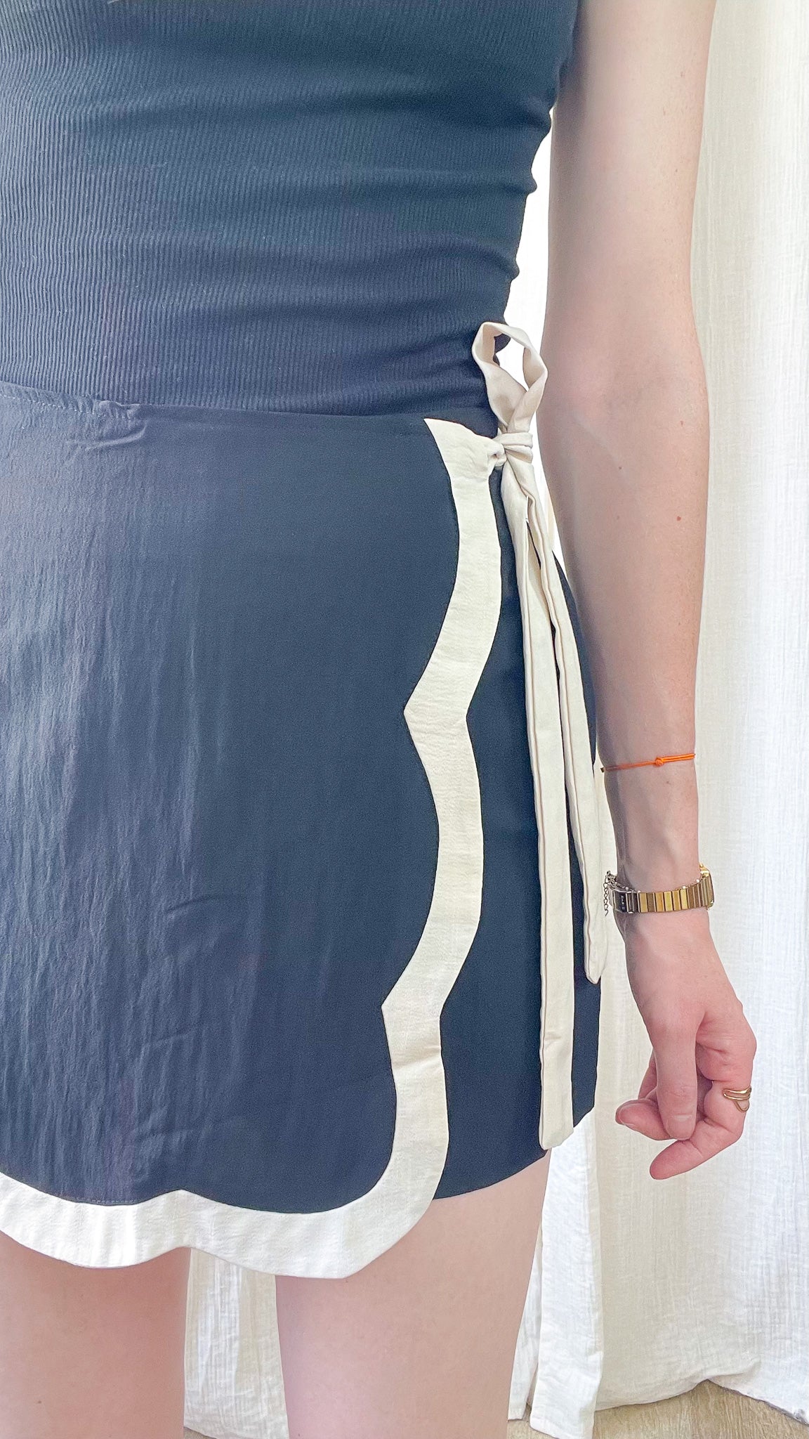 Jupe-short portefeuille bleu marine festonnée bordure écrue avec lien à nouer côté femme style élégant
