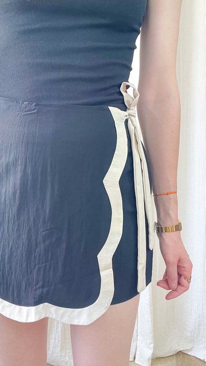 Jupe-short portefeuille bleu marine festonnée bordure écrue avec lien à nouer côté femme style élégant
