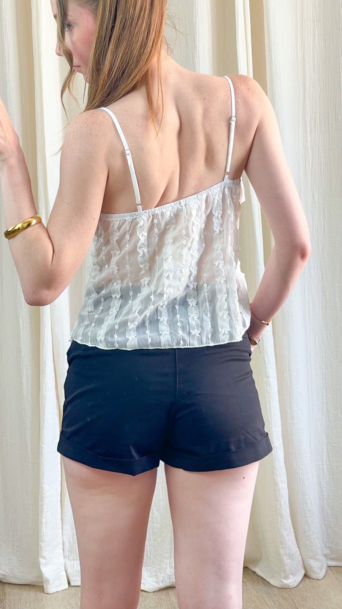 Top blanc à bretelles fines avec détails volantés et transparence légère, style romantique femme été